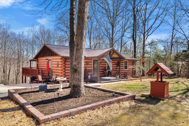 log cabin featuring metal roof and log exterior