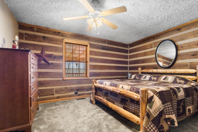 bedroom featuring a textured ceiling, wood walls, and carpet