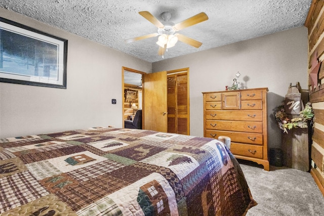 bedroom with light carpet, a closet, a textured ceiling, and a ceiling fan