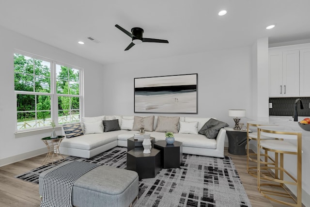 living room featuring a ceiling fan, recessed lighting, visible vents, and light wood-style floors