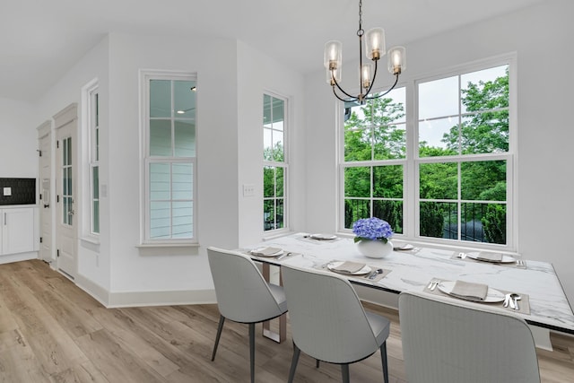 dining room with a wealth of natural light, a notable chandelier, and wood finished floors