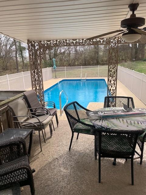 view of pool featuring a patio, a fenced backyard, a fenced in pool, and a ceiling fan