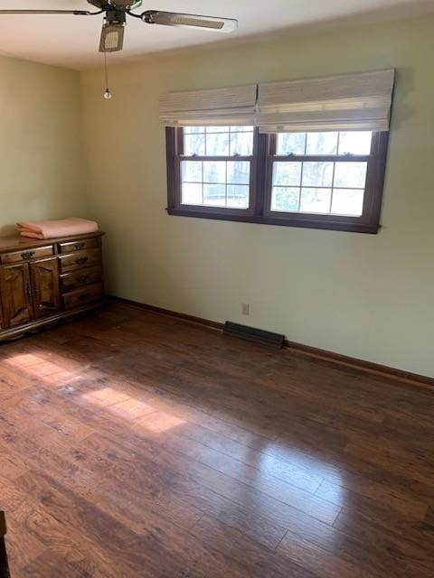 empty room with wood-type flooring, visible vents, baseboards, and a ceiling fan