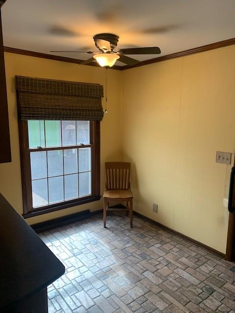 unfurnished room with baseboards, ceiling fan, brick floor, and crown molding