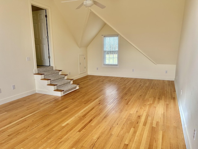 bonus room featuring stairway, light wood-style floors, vaulted ceiling, ceiling fan, and baseboards