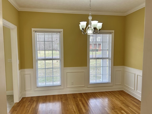 unfurnished dining area featuring a chandelier, plenty of natural light, and light wood finished floors