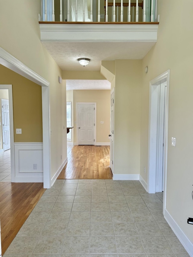 hall featuring tile patterned flooring and baseboards