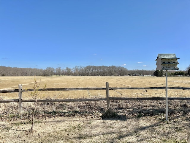 view of yard with fence and a rural view