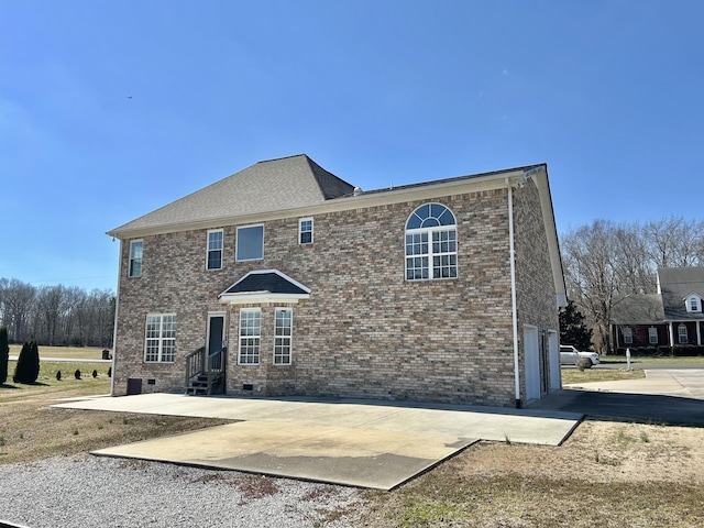 view of front of home with entry steps, driveway, brick siding, and crawl space