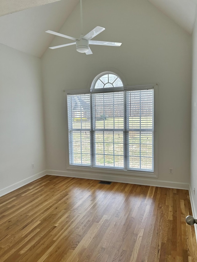 unfurnished room with a healthy amount of sunlight, visible vents, and wood finished floors
