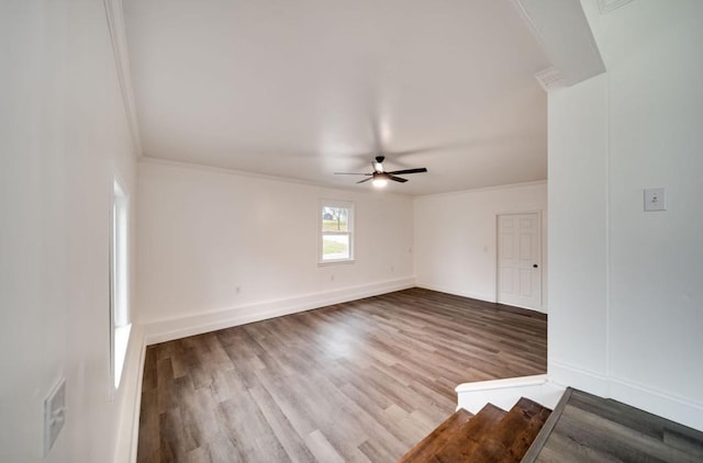 unfurnished room featuring ceiling fan, crown molding, baseboards, and wood finished floors