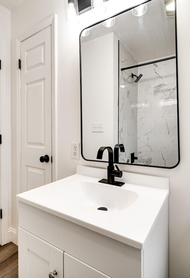 bathroom with walk in shower, wood finished floors, and vanity