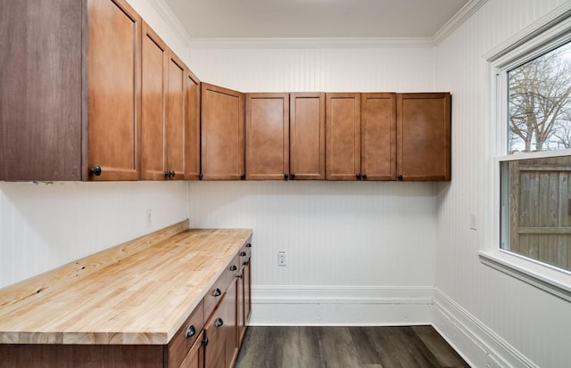 kitchen with butcher block countertops, dark wood-style flooring, baseboards, ornamental molding, and brown cabinetry