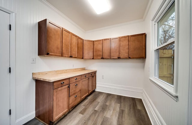 interior space featuring dark wood-type flooring, brown cabinets, and ornamental molding