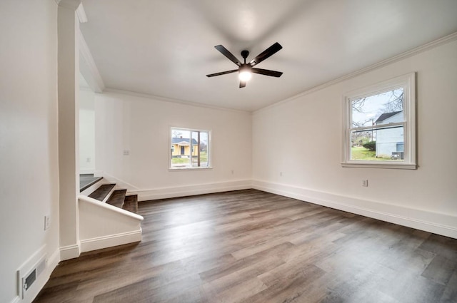 empty room featuring baseboards, visible vents, dark wood-type flooring, stairs, and crown molding