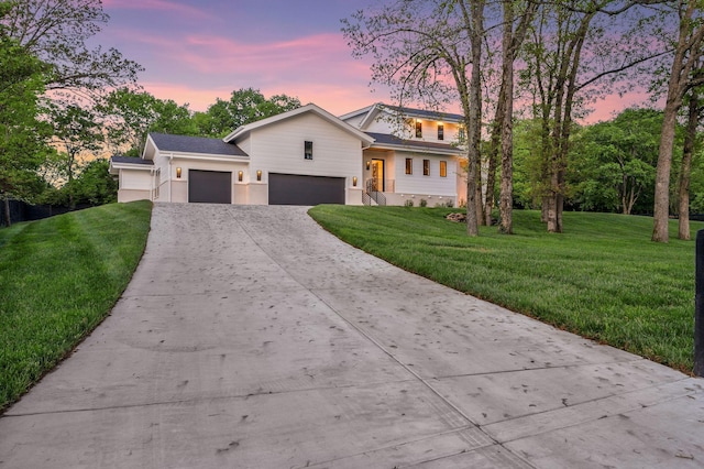 view of front facade featuring a garage, driveway, and a yard