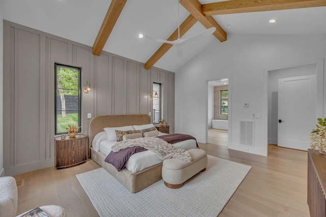 bedroom with visible vents, beamed ceiling, multiple windows, and a decorative wall
