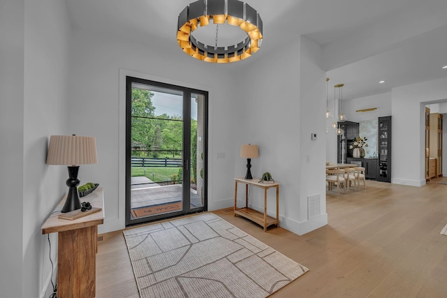 foyer featuring wood finished floors, visible vents, recessed lighting, and baseboards