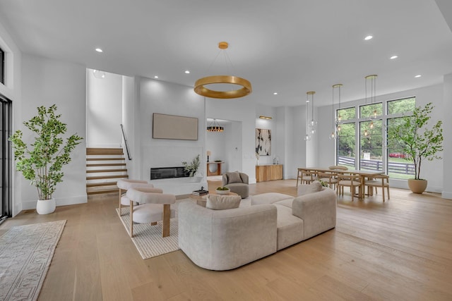 living room with recessed lighting, light wood finished floors, and baseboards