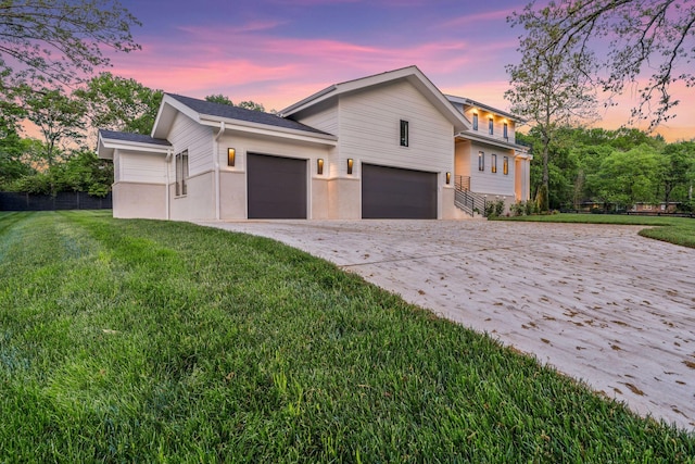 view of front facade featuring concrete driveway, a yard, and an attached garage