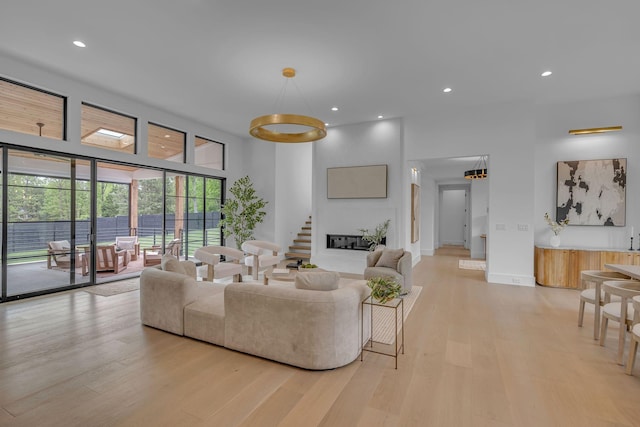 living area featuring recessed lighting, stairway, and light wood-style floors