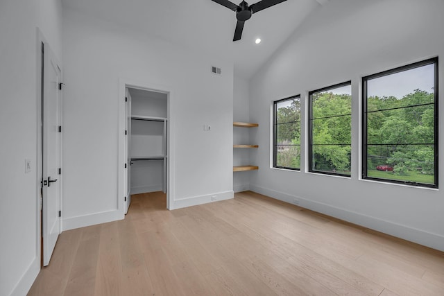unfurnished bedroom with light wood-style flooring, visible vents, baseboards, recessed lighting, and a walk in closet
