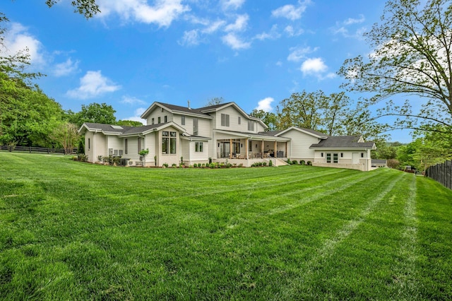 back of house with a fenced backyard and a lawn