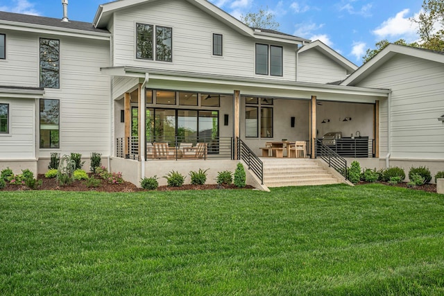 back of property featuring a lawn and ceiling fan