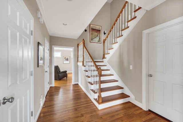 entryway with baseboards, stairway, and wood finished floors