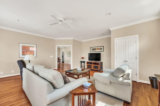 living area with recessed lighting, ornamental molding, a ceiling fan, wood finished floors, and baseboards