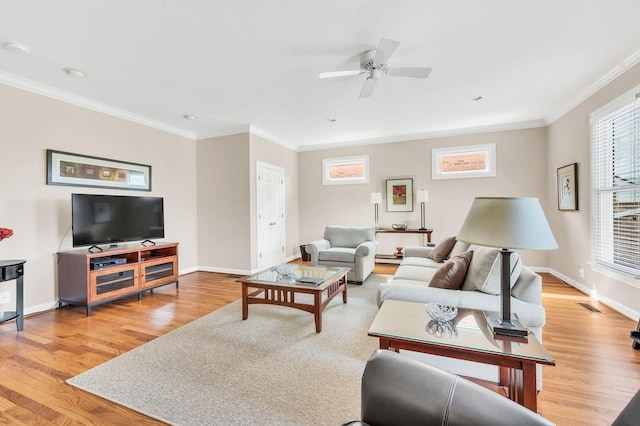 living room featuring baseboards, ornamental molding, and light wood-style floors