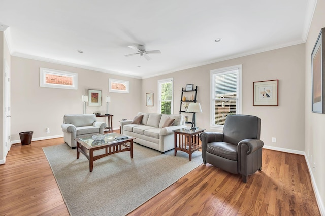 living room with ornamental molding, ceiling fan, baseboards, and wood finished floors