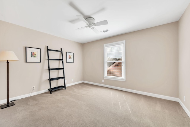 unfurnished room with light carpet, visible vents, a ceiling fan, and baseboards