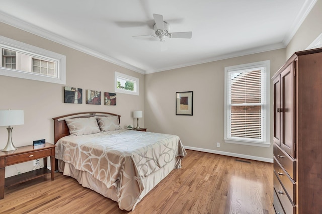 bedroom featuring baseboards, light wood-style floors, visible vents, and crown molding