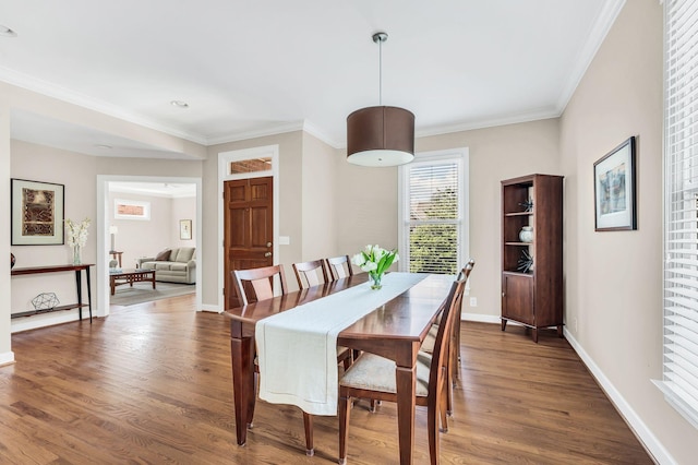 dining space featuring ornamental molding, wood finished floors, and baseboards