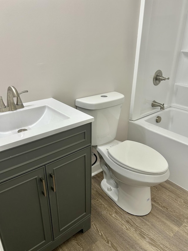 bathroom with tub / shower combination, vanity, toilet, and wood finished floors