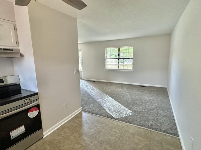 carpeted spare room featuring ceiling fan and baseboards