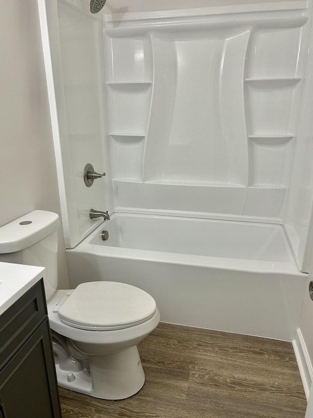 full bath with  shower combination, vanity, toilet, and wood finished floors