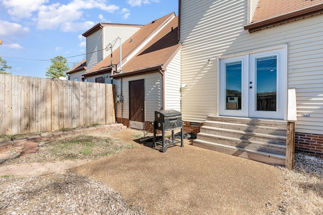 exterior space featuring french doors, a patio, entry steps, a fenced backyard, and an outdoor structure