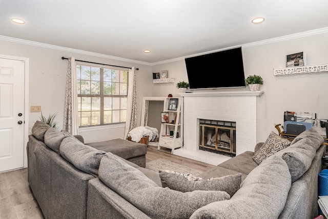 living area with a brick fireplace, crown molding, wood finished floors, and recessed lighting