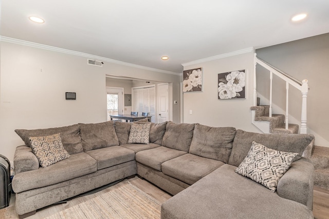 living area featuring light wood-style flooring, visible vents, stairway, and ornamental molding