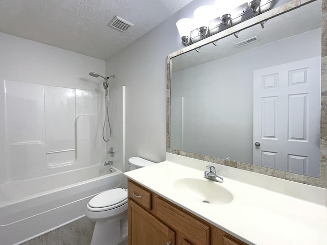 bathroom featuring toilet, visible vents, a textured ceiling, and vanity