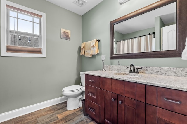 full bathroom with baseboards, visible vents, toilet, wood finished floors, and vanity