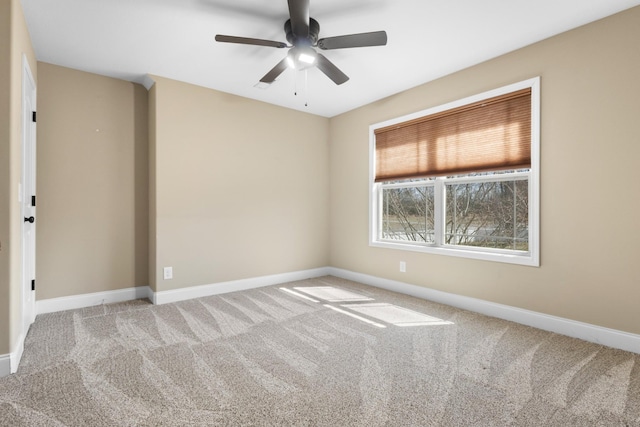 spare room featuring a ceiling fan, carpet, and baseboards