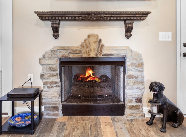 interior details featuring a fireplace, wood finished floors, and baseboards