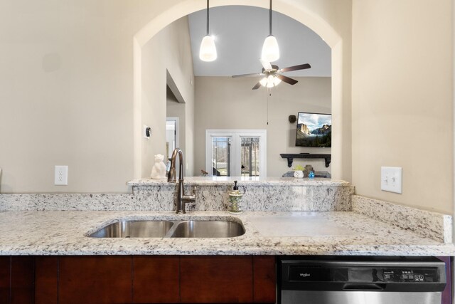 kitchen featuring ceiling fan, a sink, stainless steel dishwasher, and light stone countertops