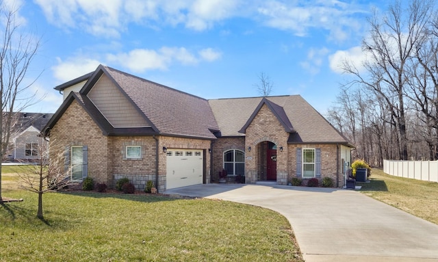 view of front of house with brick siding, a shingled roof, an attached garage, a front yard, and fence