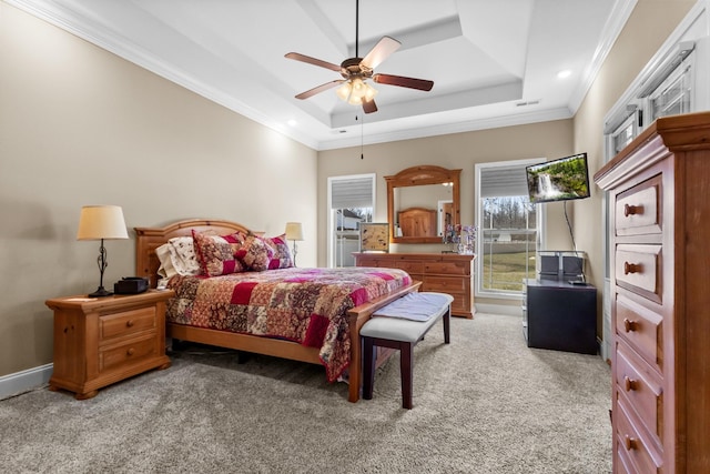 carpeted bedroom with a tray ceiling, visible vents, ornamental molding, a ceiling fan, and baseboards