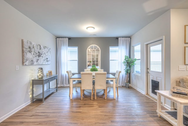 dining room with a wealth of natural light, baseboards, and wood finished floors