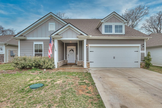 view of front of home featuring a shingled roof, board and batten siding, a front yard, a garage, and driveway